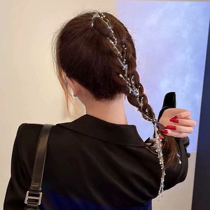 Dettaglio di una catena per capelli con strass argento indossata su una coda di cavallo