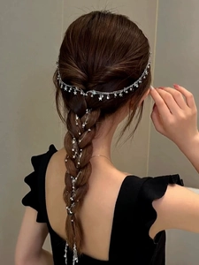 Dettaglio della catena per capelli argentata con stelle intrecciata in una treccia