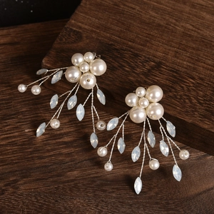 Elegante Schuhclips für Bräute mit Perlen und blauen Marquise-Kristallen auf dunklem Holz
