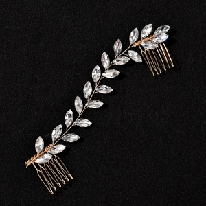 Detail of golden bridal hair vine with marquise crystals and double combs on black fabric