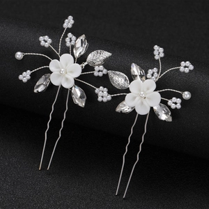 Détails d'épingles à cheveux fleurs blanches avec perles et cristaux sur fond noir