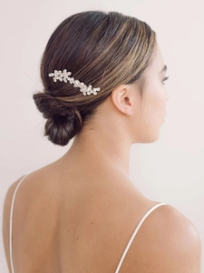 Close-up of sparkling bridal rhinestone flower hair comb styled in a low bun