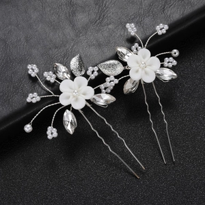 Détail de l'épingle à cheveux mariée avec fleurs en argile, perles et cristaux sur cuir noir