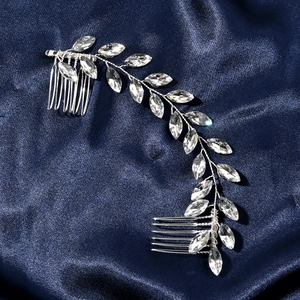 Detail of silver bridal hair comb with marquise crystal leaves on navy background