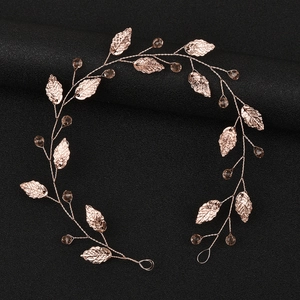 Detail of rose gold leaf bridal hair vine with crystal beads on a black background