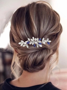 Détail d'un peigne de mariée avec cristaux bleu roi et blancs dans un chignon élégant