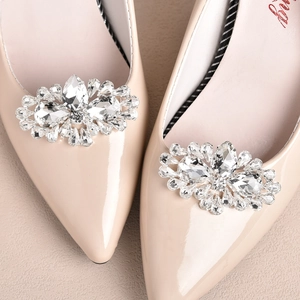 Sparkling rhinestone shoe clips on elegant pointed-toe patent leather bridal pumps