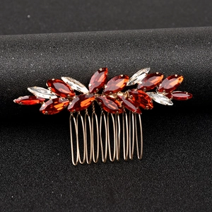 Nahaufnahme eines Vintage-Haarkamms für Bräute mit roten Kristallen und Goldlegierung