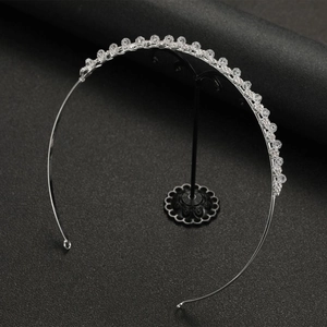Detailed view of handmade crystal bridal headband on a black display stand