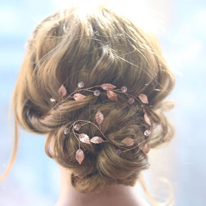 Rose gold leaf bridal hair vine with crystal beads styled on an elegant wedding updo