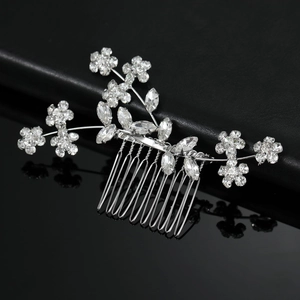 Vista macro del pettine per capelli argento con fiori in strass su pelle nera di lusso