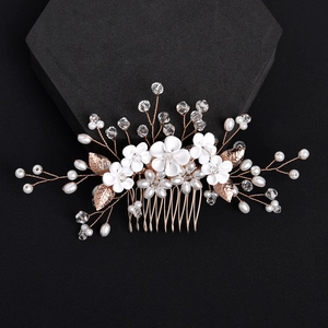 Elegant white floral bridal hair comb with pearls and rose gold leaves on dark background