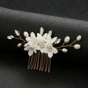 Elegant bridal hair comb with white ceramic flowers, pearls, and crystals on gold wire