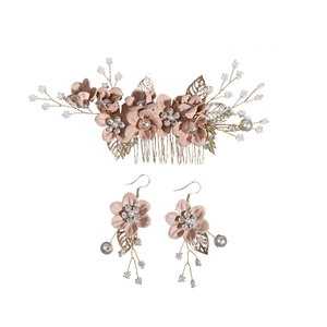 Detail of pink fabric flowers, pearls, and crystals on a bridal hair comb and earring set