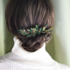 Pettine per capelli da sposa con cristalli marquise verdi e rami dorati su una modella