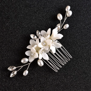 Handmade bridal hair comb with white ceramic flowers, pearls, and crystals on silver pin