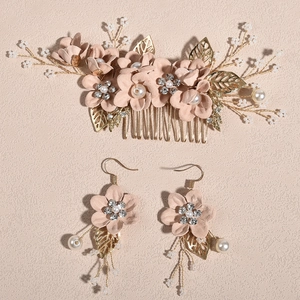 Detail of bridal hair comb and drop earrings set with pink fabric flowers and pearls