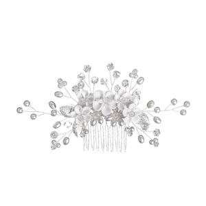 Macro detail of bridal hair comb with white fabric flowers and silver beaded branches