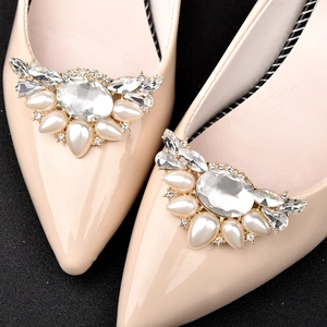 Elegante beige spitze Schuhe mit luxuriösen Kristall- und Perlenschnallen auf schwarzem Grund