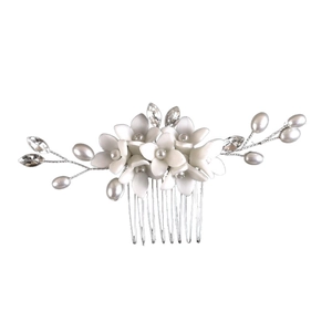 Macro detail of bridal hair comb featuring white ceramic flowers and silver crystal accents