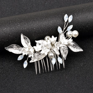 Detail of silver alloy bridal hair comb with white ceramic flowers and pearls