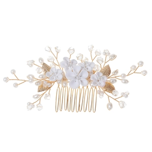 Detail of handmade bridal hair comb with white ceramic flowers and gold wire leaves