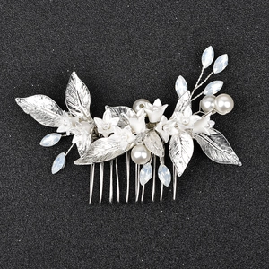 Detail of silver bridal hair comb with white ceramic flowers, pearls and crystal drops