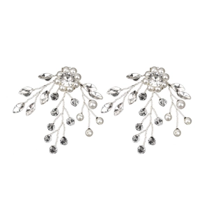Clip per scarpe da sposa fatte a mano con perle e strass su uno sfondo bianco puro