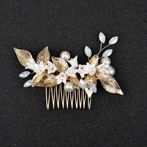 Bridal hair comb with white ceramic flowers, gold metal leaves and blue crystals