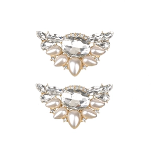 Detail von eleganten goldenen Schuhclips mit großem Kristall und Tropfenperlen-Akzenten