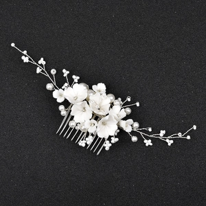 Détail d'un peigne à cheveux de mariée fait main avec fleurs blanches et perles nacrées