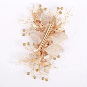 Detail view of gold leaf hair clip back showing spring mechanism and wire-wrapped pearls