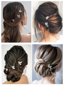 Detail view of silver bridal hair pins with sparkling leaf-shaped crystal clusters