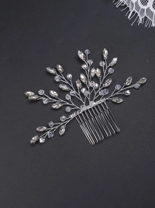 Exquisite bridal hair comb with silver metal wires, crystals, and pearls on a dark background