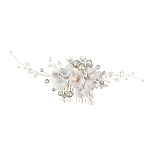 Détails de fleurs en céramique blanche et perles sur peigne à cheveux doré de mariée