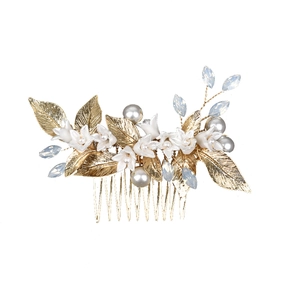 Golden bridal hair comb featuring white ceramic flowers, metal leaves and blue rhinestones