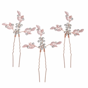 Detailed macro view of 3-piece rose gold bridal hair pins with pink leaves and rhinestones