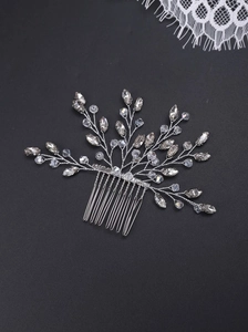 Detailed macro view of silver wedding hair comb with crystals and pearls on lace background