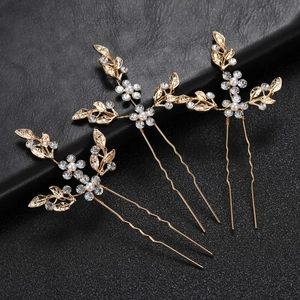 Detailed close-up of three golden leaf U-shaped hairpins with pearls and rhinestones