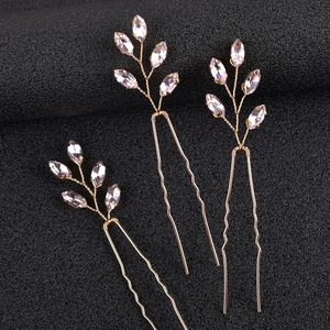 Dettaglio di tre forcine a U dorate fatte a mano con cristalli rosa taglio marquise