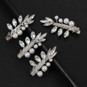 Détail de quatre épingles à cheveux de mariée argentées avec cristaux et perles blanches