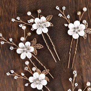 Detailed shot of bridal hair pins featuring white flowers, pearls, and gold-plated wire