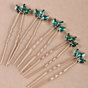 Detail view of 6-piece U-shaped hair pins with gold finish and green marquise gemstones
