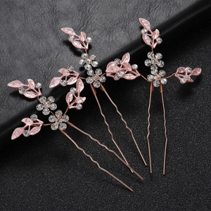 Detail of three rose gold leaf hair pins with pink enamel and sparkling rhinestones