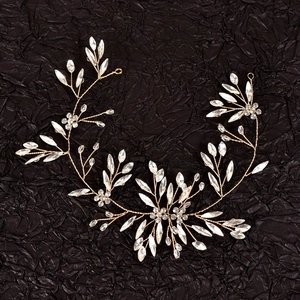 Détail d'un bandeau de mariée doré avec strass de fleurs de prunier en cristal clair