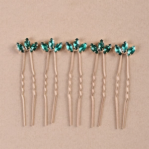Detailed macro view of 5-piece gold U-shaped hairpins with marquise green crystals