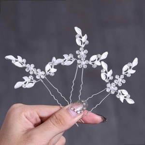 Detail of silver bridal hair pins set with crystal leaves and elegant white pearls