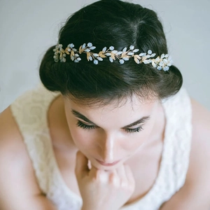Golden bridal hair vine with delicate metal leaves and blue opal stones on white lace