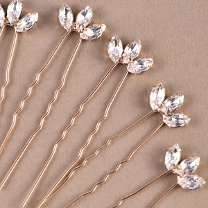 Macro detail of U-shaped hair pins with marquise-cut crystals in rose gold finish
