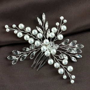 Macro detail of bridal hair comb with emerald crystals, pearls and silver wire branches